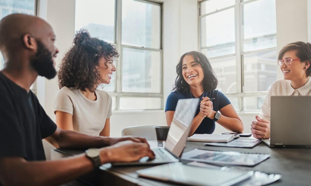 Business team collaborating confidently while IT professionals manage a complex network in the background, symbolizing strategic managed IT services for small business.